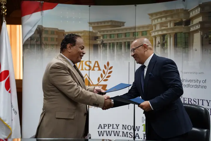 Eng. Mahmoud Nouh and the MSA University representative shake hands after signing the protocol